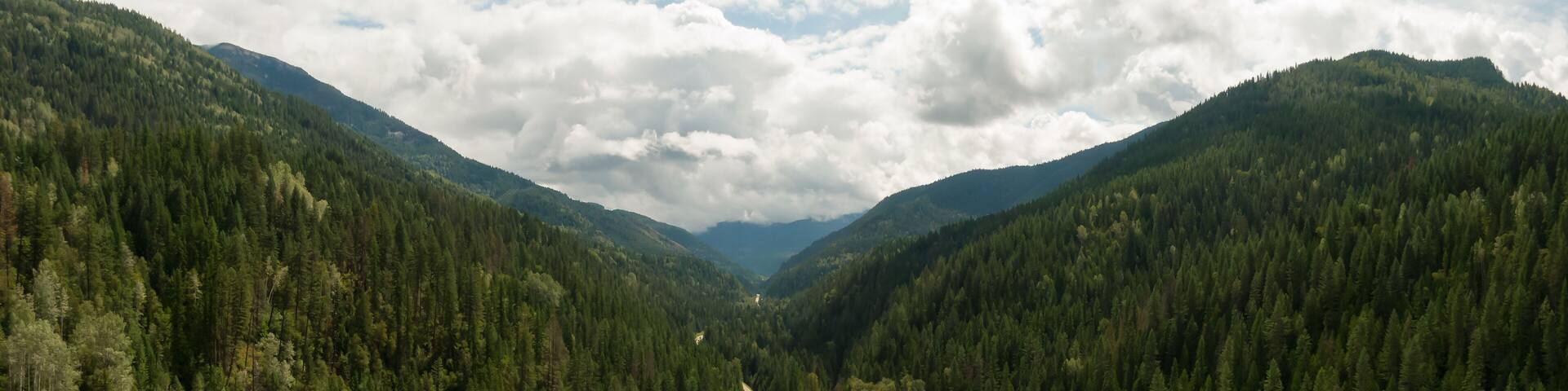 Aerial Panoramic View of a Scenic Highway in the Valley surrounded by Canadian Mountain Landscape. Taken near Salmo, British Columbia, Canada.