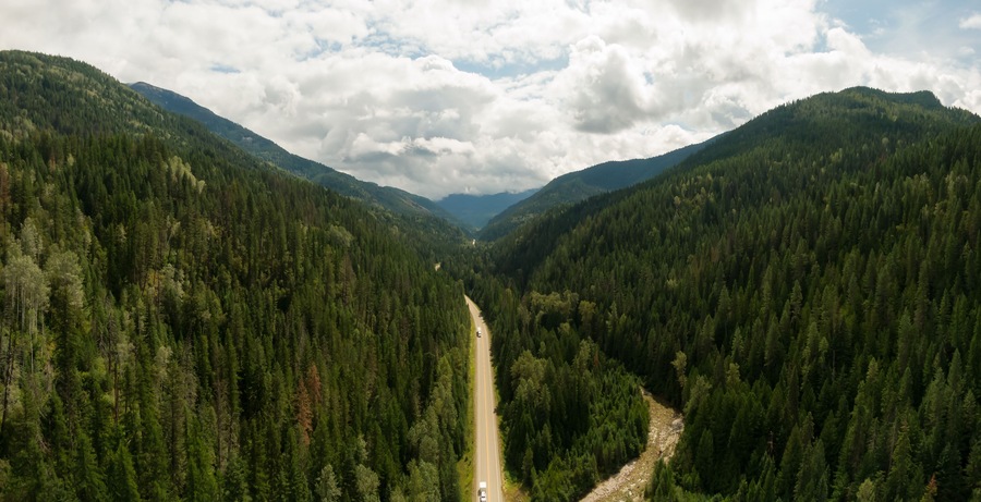 Aerial Panoramic View of a Scenic Highway in the Valley surrounded by Canadian Mountain Landscape. Taken near Salmo, British Columbia, Canada.