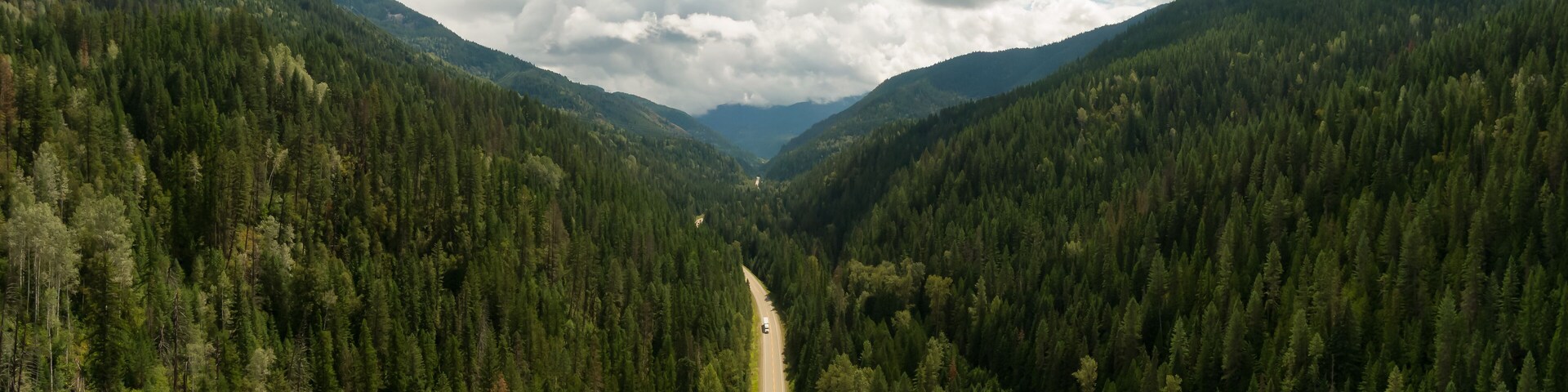 Aerial Panoramic View of a Scenic Highway in the Valley surrounded by Canadian Mountain Landscape. Taken near Salmo, British Columbia, Canada.