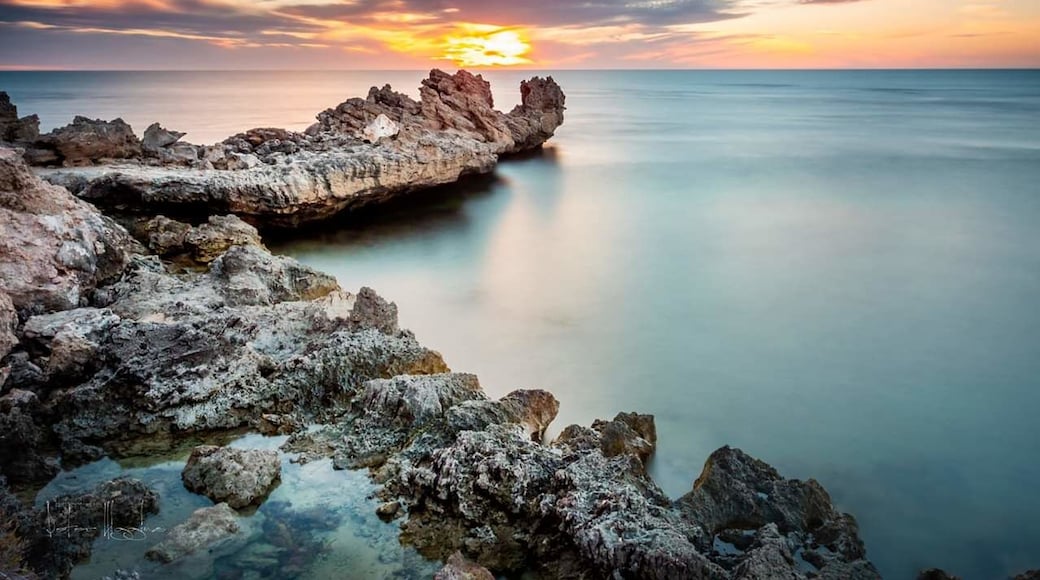 An umusually calm Indian Ocean as the sun sets over Point Peron