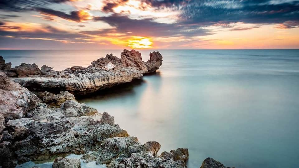 An umusually calm Indian Ocean as the sun sets over Point Peron