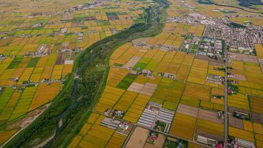 After taking off from Asahikawa Airport in Hokkaido, Japan, an aerial view reveals Higashikagura Town to the east (in the middle right) and the Chubetsu River (in the center).