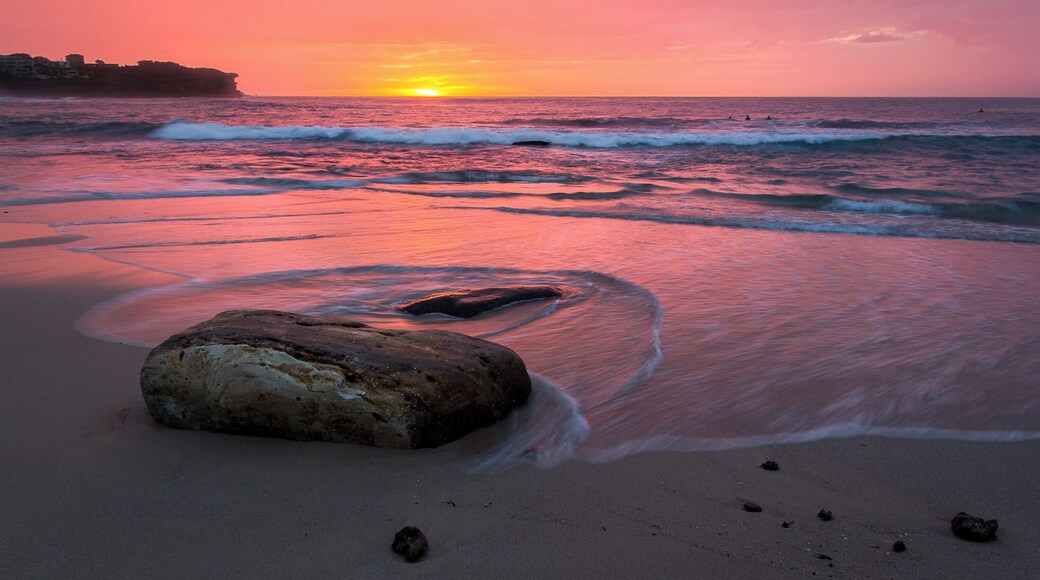 Bronte is popular with surfers as it gets larger waves than its neighbours. A couple can be seen in the water during this sunrise shot.