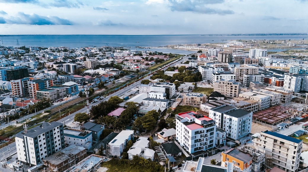 Aerial view of urban sprawl meets the ocean's edge, a tapestry of buildings contrasting with the blue horizon, Lekki, Lagos, Nigeria.