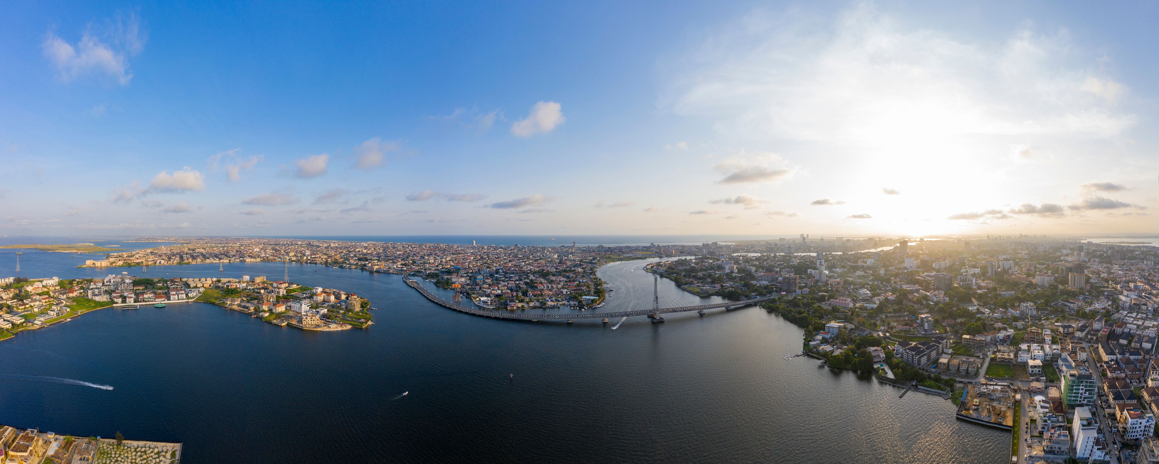 An aerial view of a city with a river, a bridge, and a peninsula with buildings.
