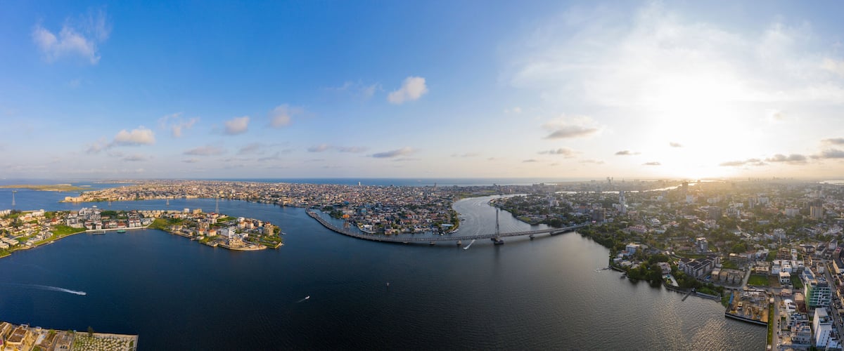 An aerial view of a city with a river, a bridge, and a peninsula with buildings.