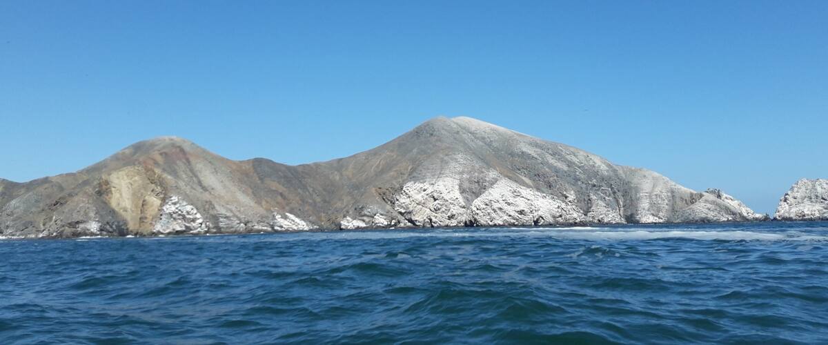 A mountain range with snow-capped peaks and a clear blue sky.