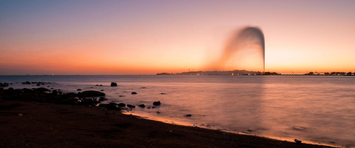 Panoramic view of the King Fahd's Fountain seen from the South Corniche, Jeddah, Saudi Arabia, with a beautiful sunset in the background