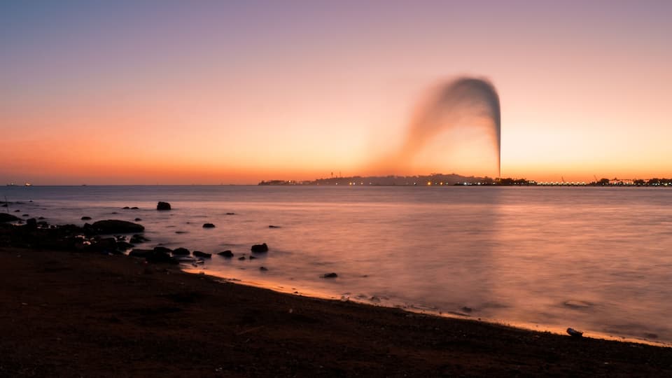 Panoramic view of the King Fahd's Fountain seen from the South Corniche, Jeddah, Saudi Arabia, with a beautiful sunset in the background