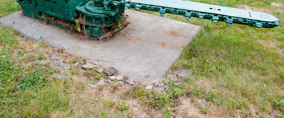 A large green mechanical device in a grassy field.