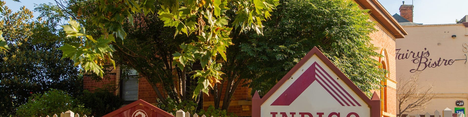 A historic district sign for Indigo Shire, a historic district sign for Wahgunyah, and a white picket fence.