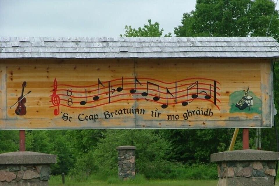 A wooden sign with musical notes and a violin, featuring the text "Se Ceap Breataun tir mo ghlraith".