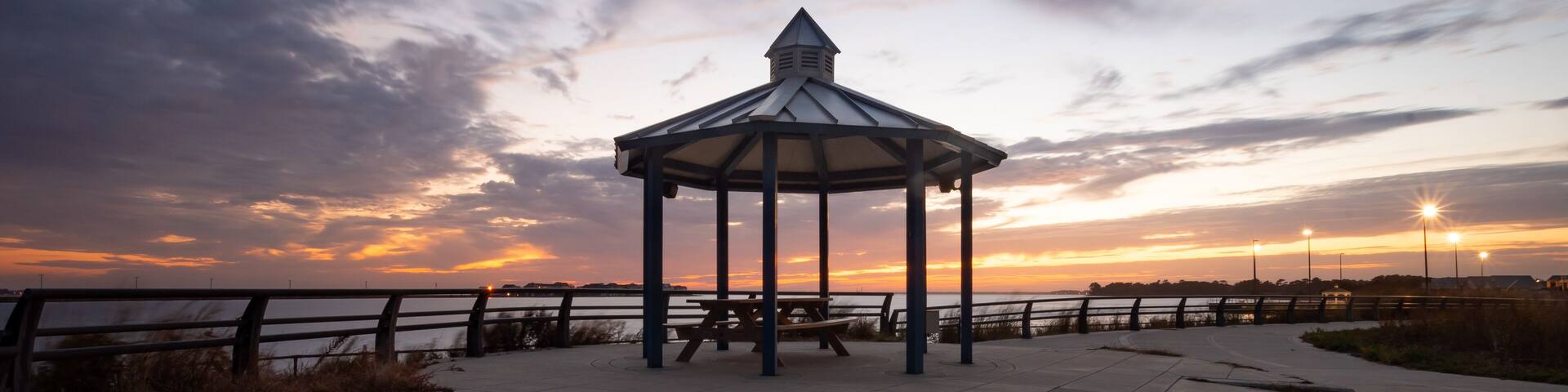 Gazebo in a Park with a Picnic Table with a Colorful Sunset Sky Background