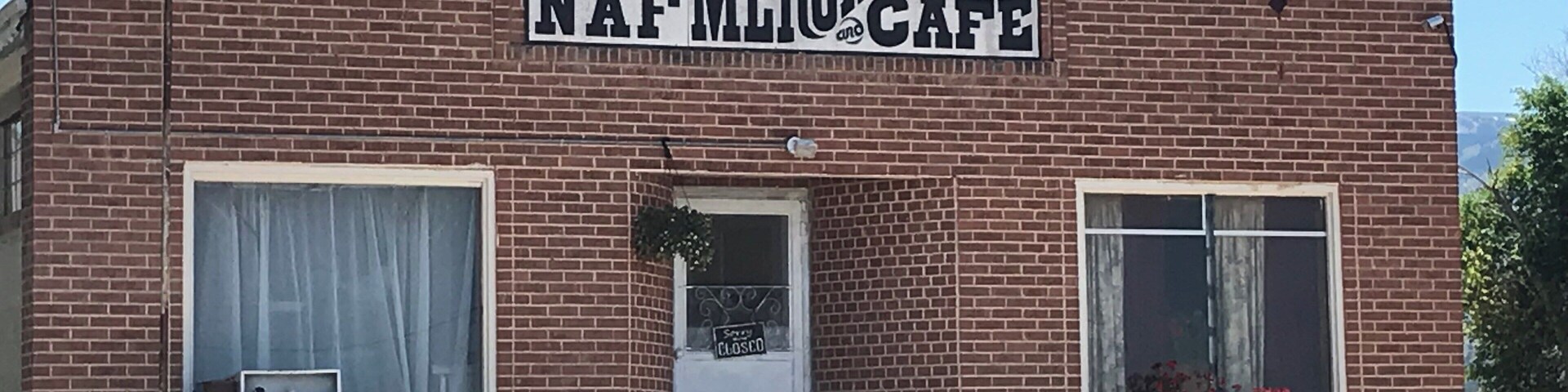 A brick building with a sign that reads "Buck's Mercantile NAF Cafe".