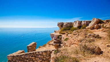 Um penhasco costeiro com uma escadaria de pedra que desce até o mar.