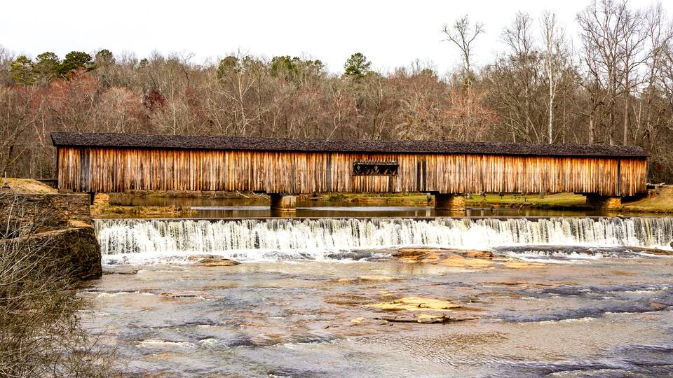 A rustic wooden bridge over a waterfall.