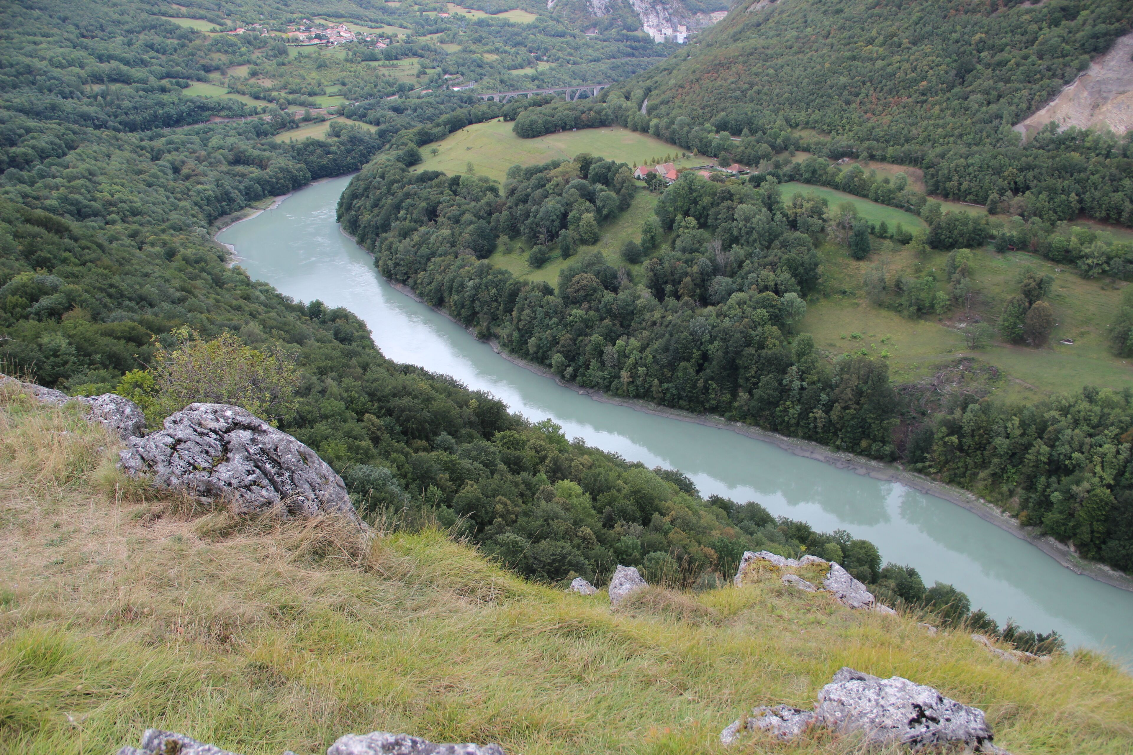 A river winding through a valley with dense forests and rocky outcrops.