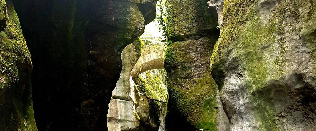 A narrow rock passage with a metal walkway and a viewing platform.