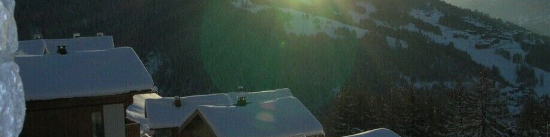 A snowy mountain village with wooden cabins and a clear sky.
