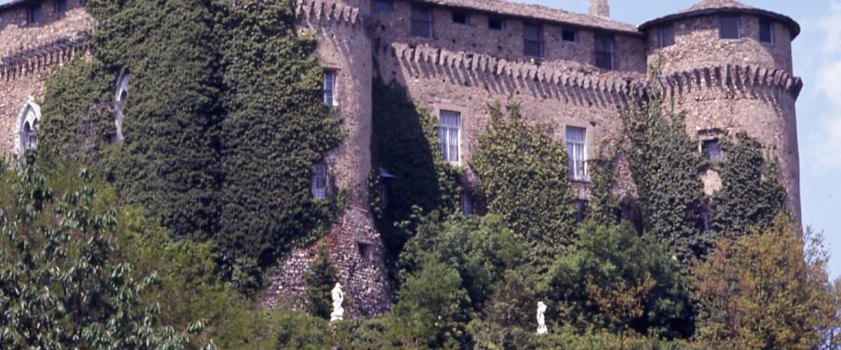 A historic stone castle with ivy-covered walls and a round tower.