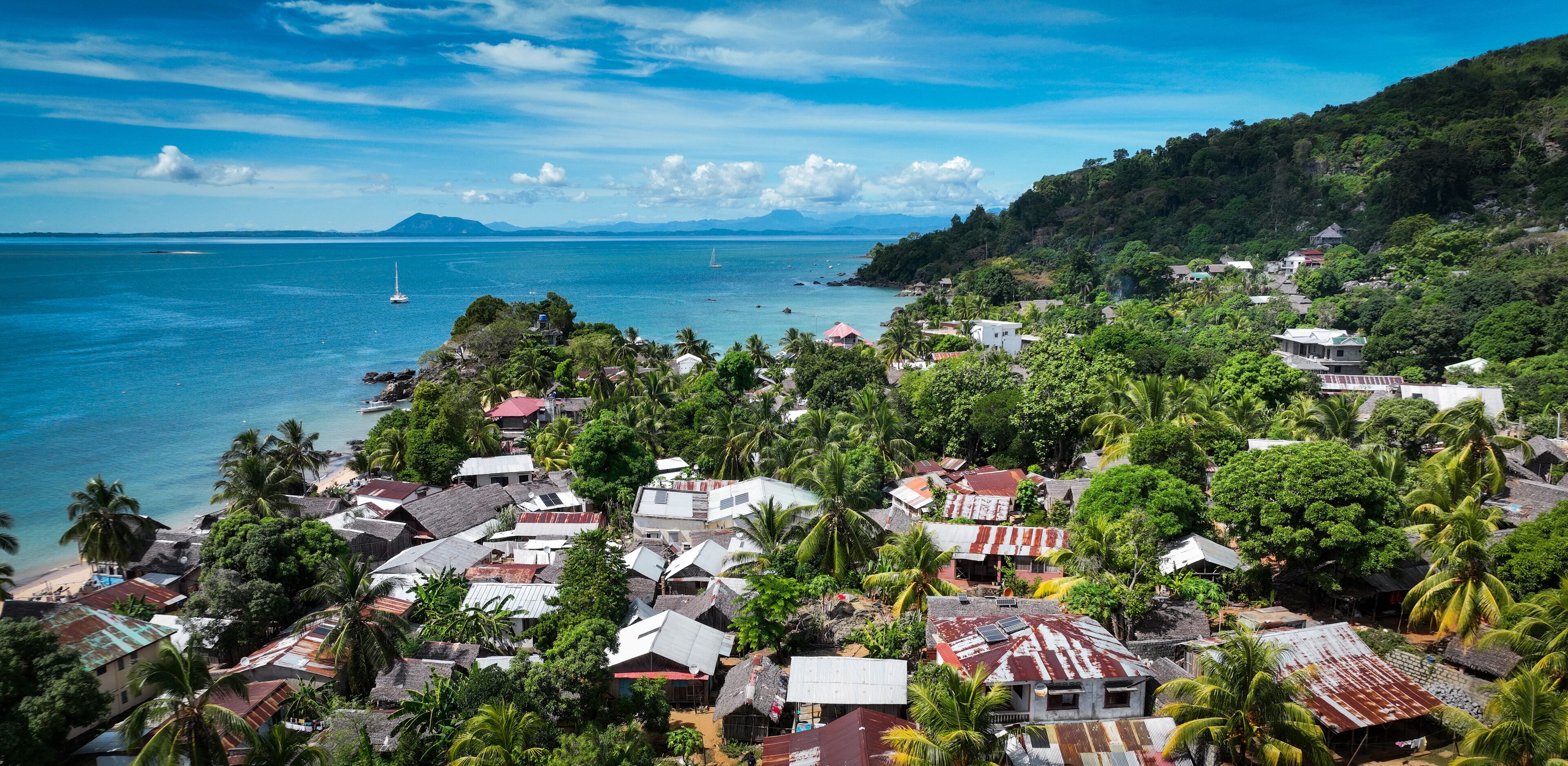 Aerial view of Nosy Komba Island in Madagascar showcasing vibrant greenery and coastal beauty on a sunny day