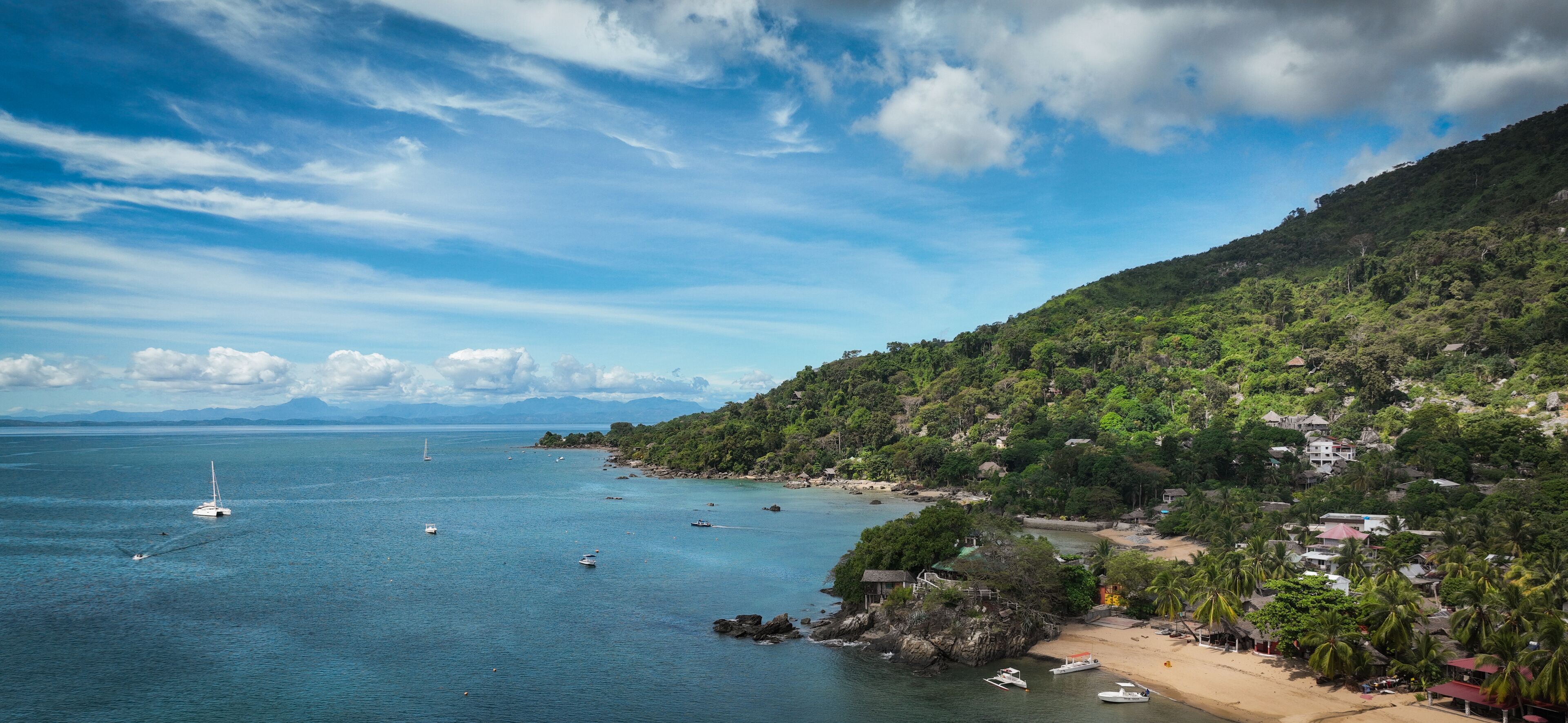 Aerial view of Nosy Komba Island in Madagascar showcasing tranquil waters, lush greenery, and scenic coastal villages during the day