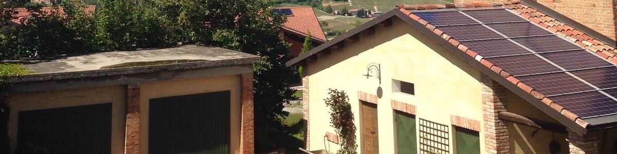 Un paysage rural avec une maison en briques, un garage et une installation de panneaux solaires.