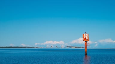 Finland, Oulu. The lighthouse in the strait between Oulunsalo and Hailuoto Island against a backdrop of beautiful clouds. In the background, a bridge under construction.