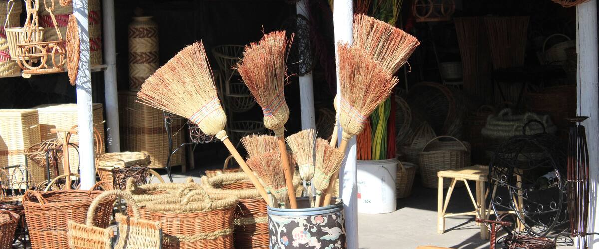 Wicker furniture and baskets displayed outside a shop.