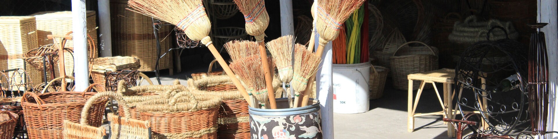 Wicker furniture and baskets displayed outside a shop.