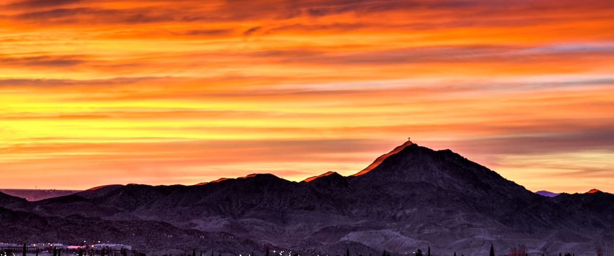 A mountain range at sunset with a vibrant sky.