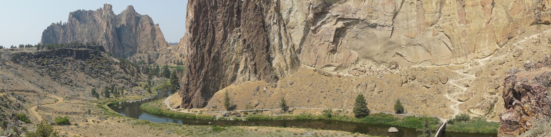 A river winding through a canyon with tall cliffs and sparse vegetation.