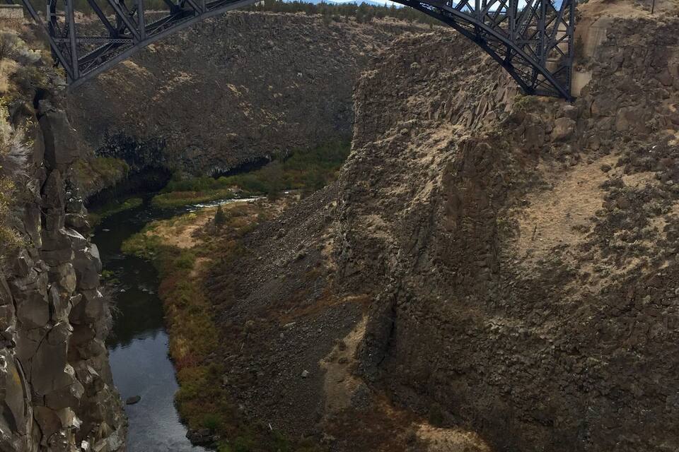 A bridge spanning a deep canyon with a river flowing through it.
