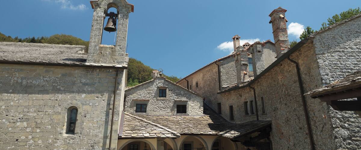 A historic stone building with a bell tower and arched windows.