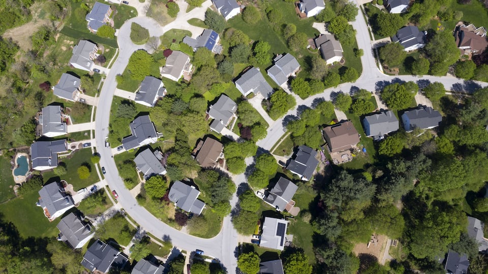 An aerial view of a residential neighborhood with houses, streets, and green spaces.