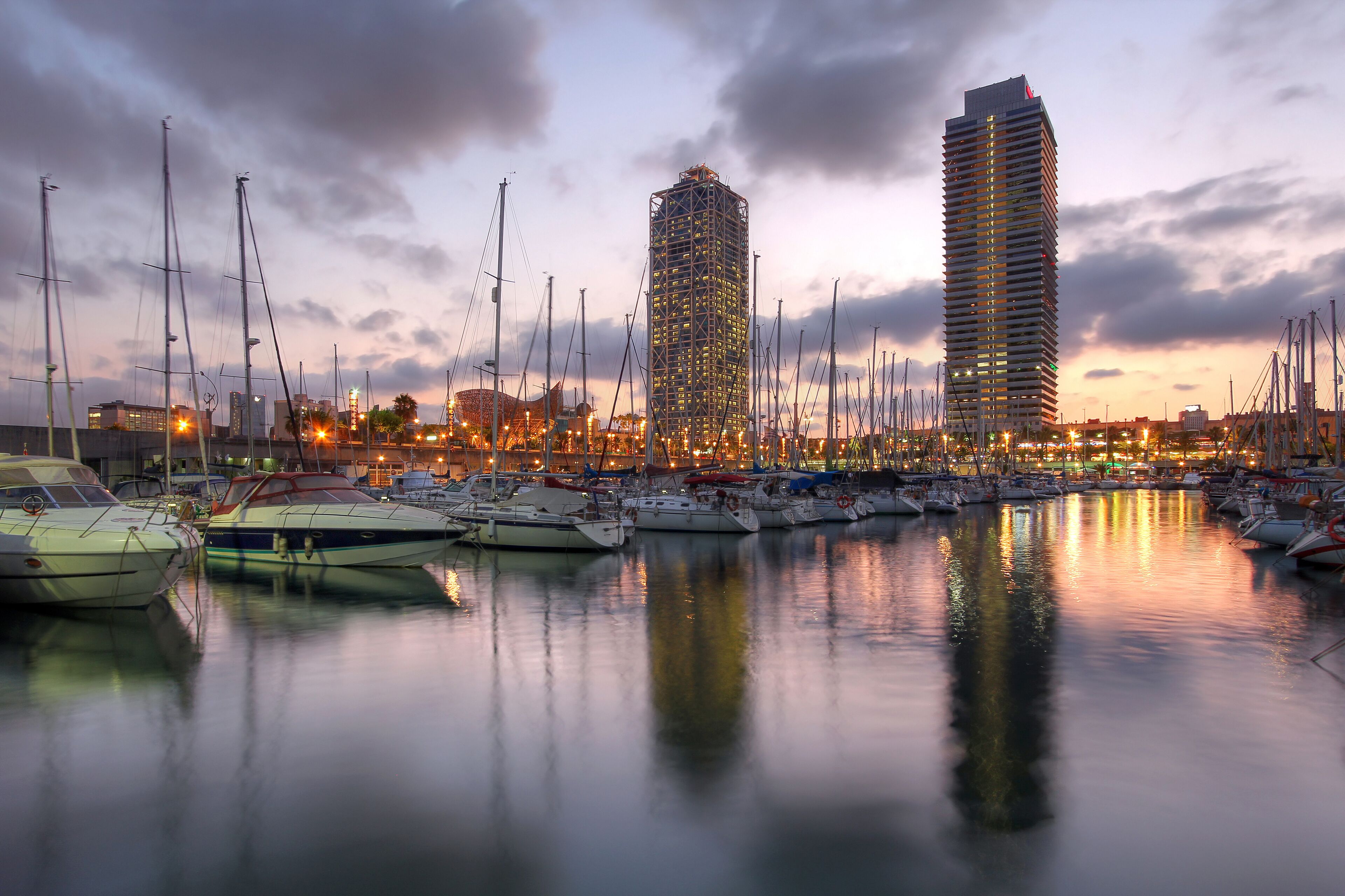 Skyscrapers towering over the marina in Port Olimpic (Olympic Harbor), Barcelona, Spain at sunset