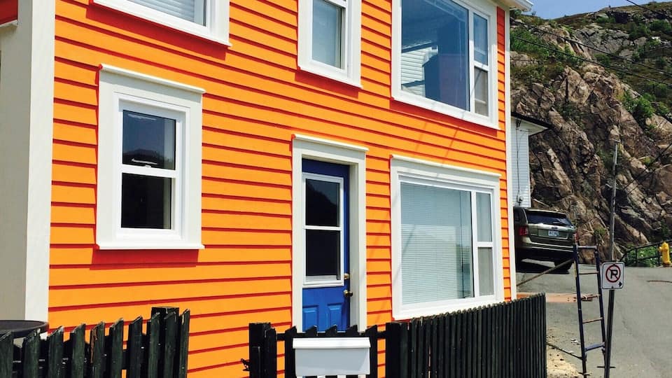 Een gebouw met twee verdiepingen, oranje bekleding en witte details.