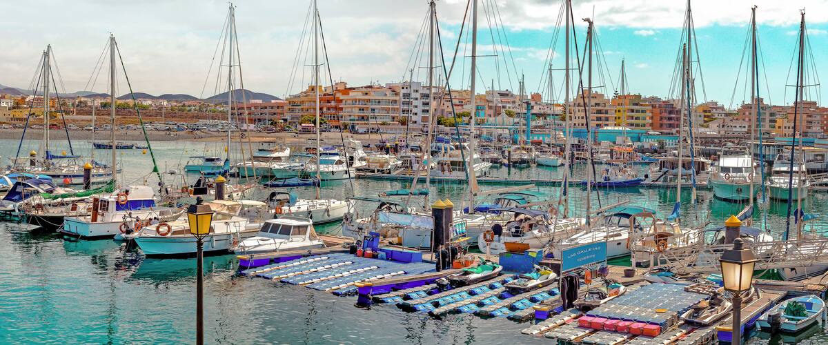 Panoramic wiew of Las Galletas port with fishing boats with the City in the background. In Tenerife. Canary Islands.
