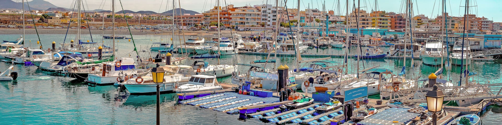 Panoramic wiew of Las Galletas port with fishing boats with the City in the background. In Tenerife. Canary Islands.