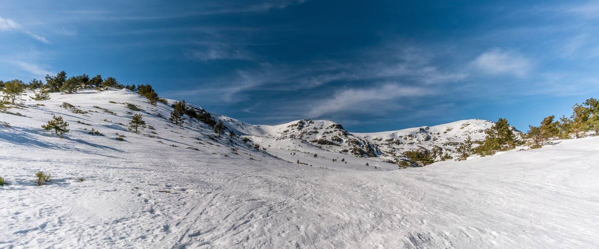A snow-covered mountain landscape with clear skies.