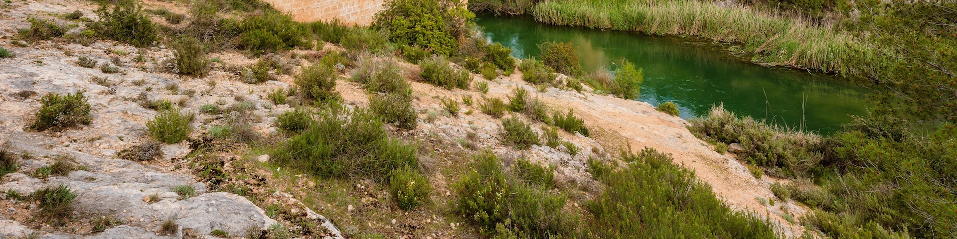Antique one arch stone bridge over a river the Hoces del Rio Cabriel Natural Park between Valencia and Cuenca in Spain. Protected Area.