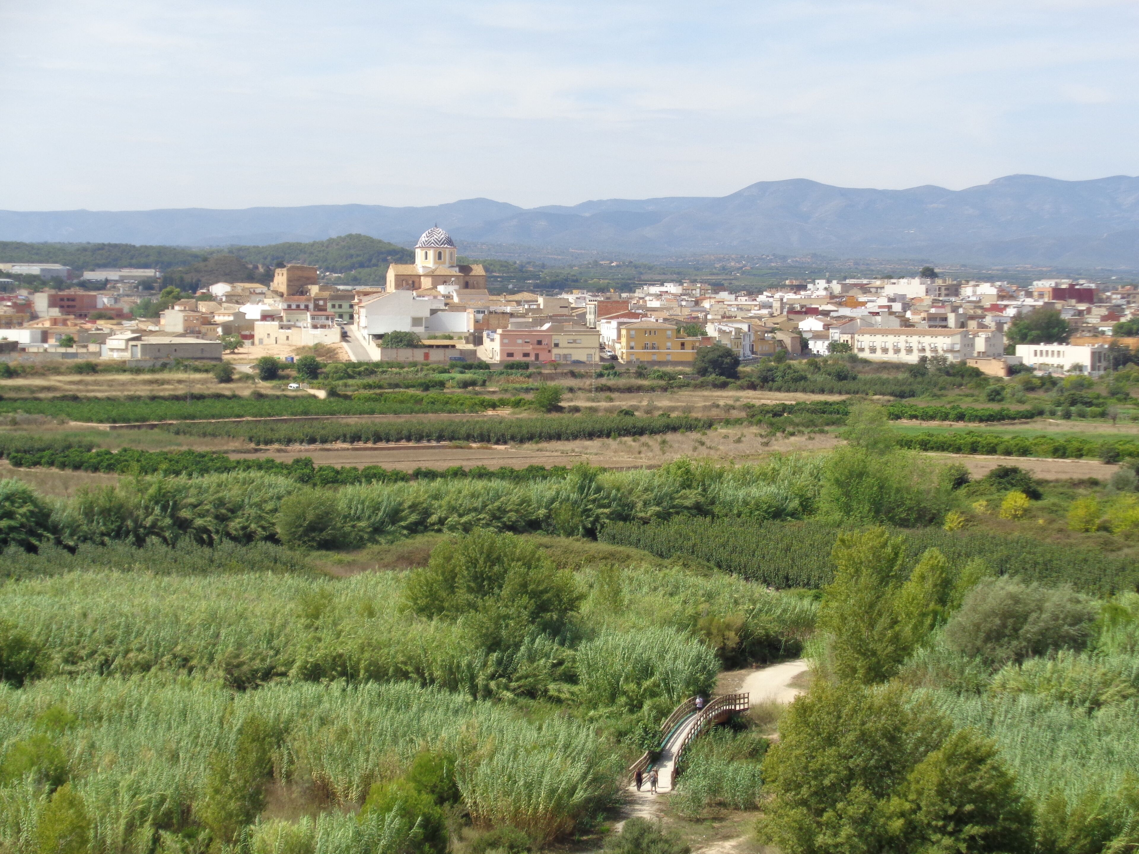 A town with a prominent church and mountains in the background.