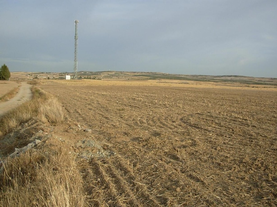 Camp sec arat amb una torre de comunicació al capdamunt.