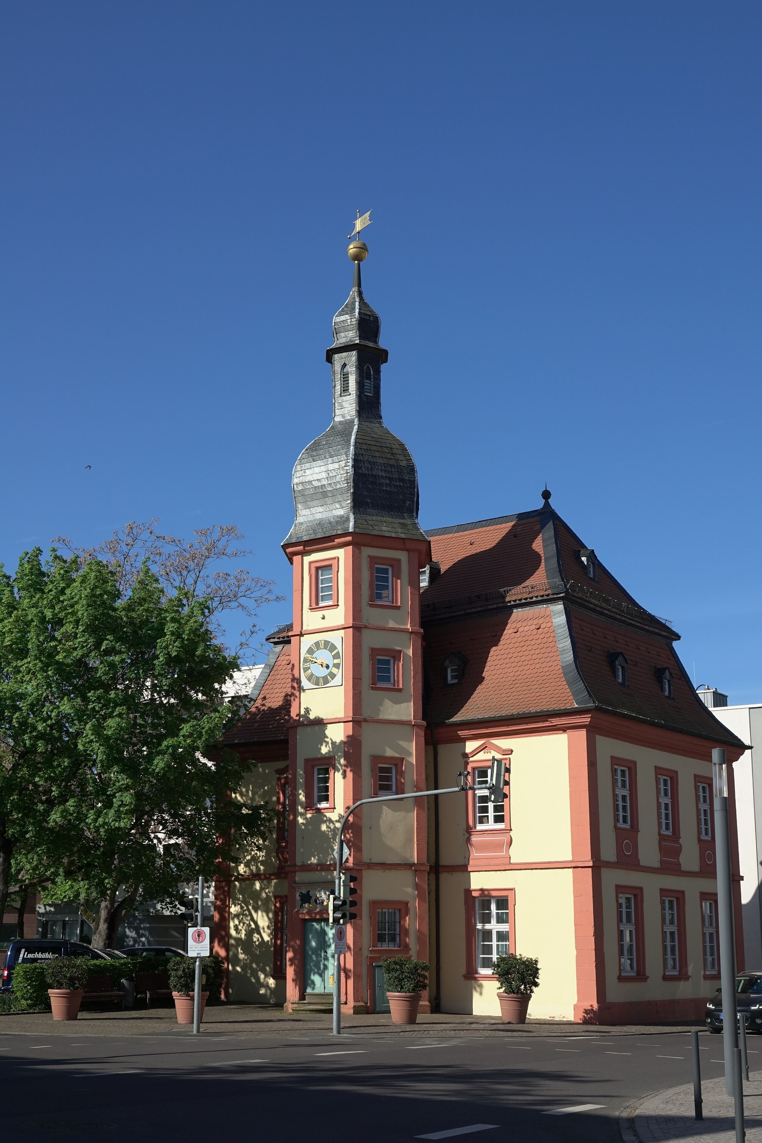 A historic building with a prominent tower, a clock, and a red roof.