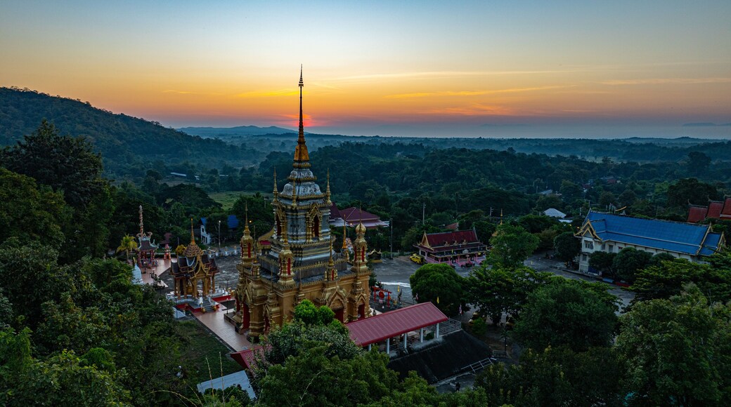 Aerial view of Mae Klang Waterfall Temple in Chiang Mai with the sunrise casting warm hues in calm sky. The tranquil setting highlights the serene beauty of the temple and the natural landscape.