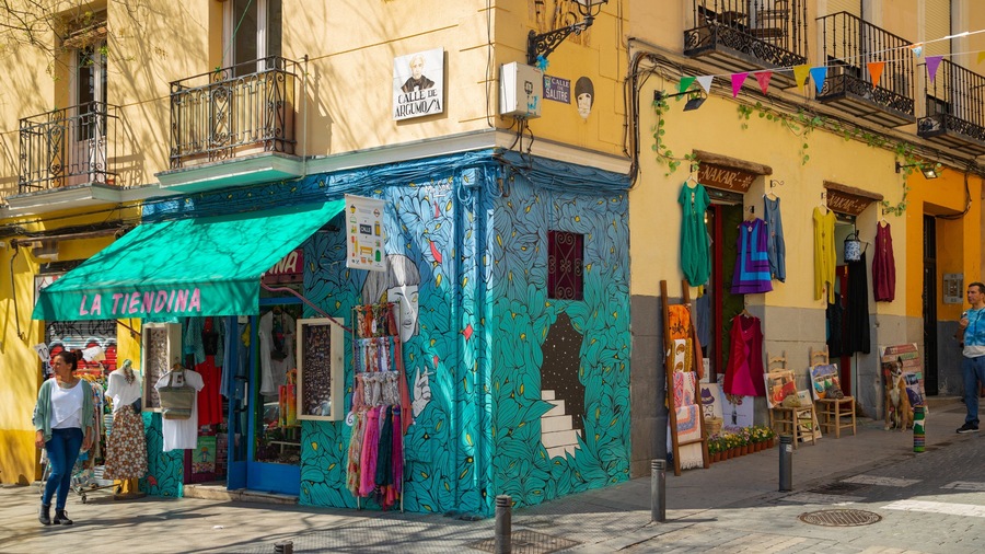 A colorful market stall with a green awning labeled "LA TIENDINA" and various textiles displayed outside.