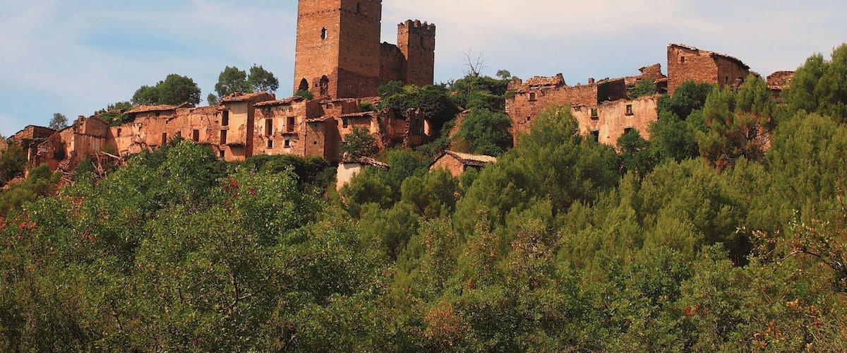 A historic hilltop town with ancient stone buildings and a prominent tower.