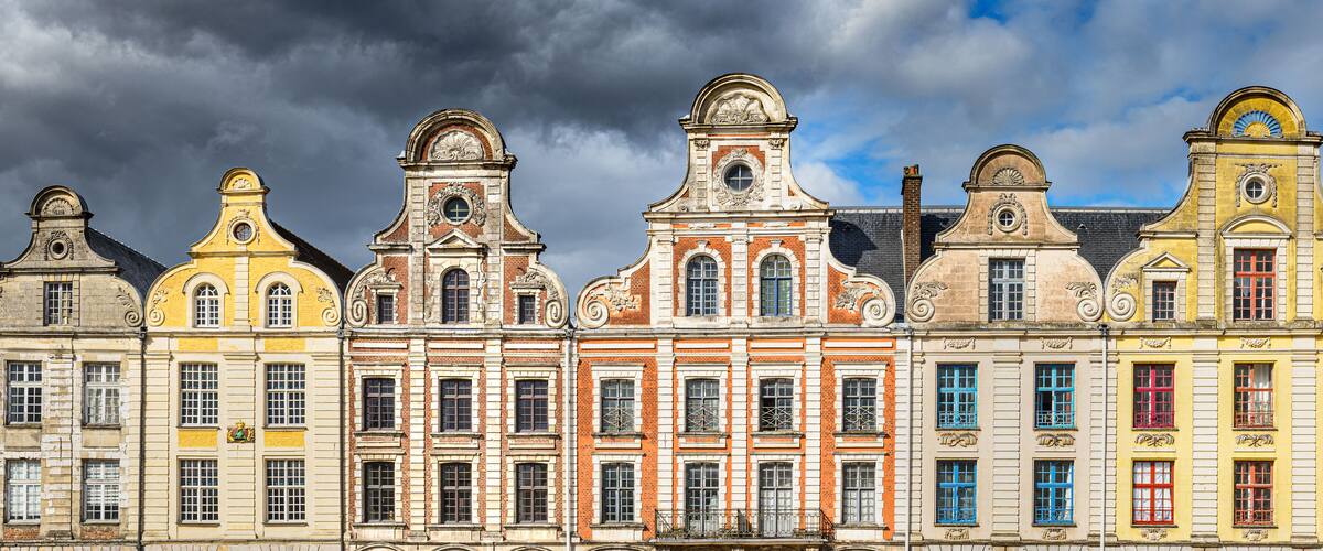 A row of colorful historic buildings with ornate facades and distinctive architectural details.