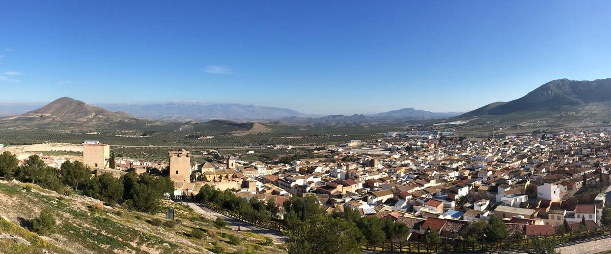 A town nestled in a valley with a prominent mountain in the background.