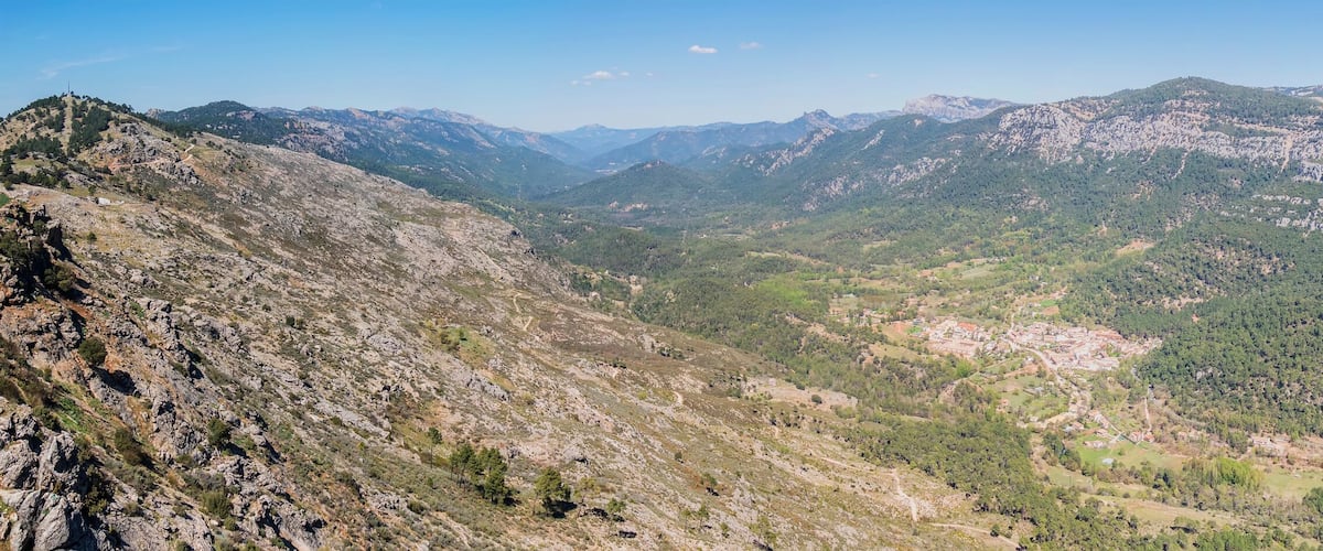 A mountainous landscape with rocky terrain and dense forests.